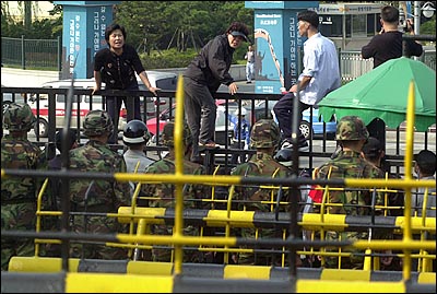 국방부 정문에 올라가 시위를 벌이는 군의문사 유가족들. 